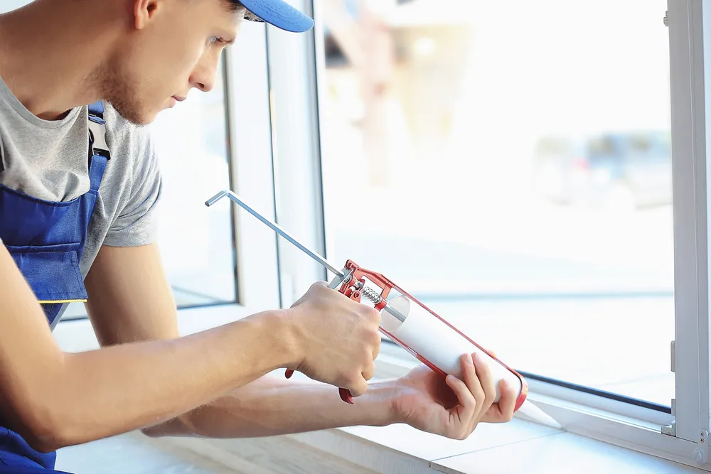 Construction worker installing window in house